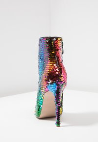 Hoge enkellaarsjes bedekt met meerkleurige pailletten, met een smalle stilettohak en een slanke, gestructureerde oppervlakte.