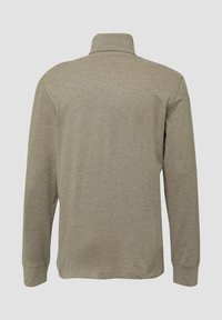 Długa koszulka polo z długim rękawem w jasnym beżowym kolorze, z kołnierzykiem, miękką fakturą i minimalną ilością szwów, o prostym kroju u dołu.