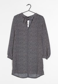 Blouse imprimée dans des couleurs sombres, avec un décolleté en V agrémenté d'un lien, des manches longues avec des poignets élastiques, et un tissu léger et fluide.