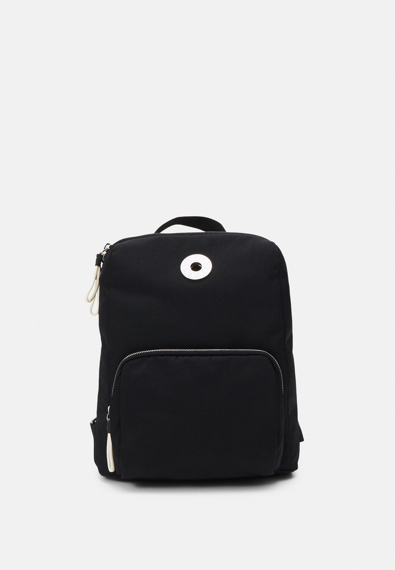 Sac à dos noir avec une texture lisse, une quincaillerie centrale ronde, une poignée supérieure et une poche zippée à l'avant. Présente un design minimaliste et des coutures discrètes.