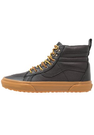 Sort højtstående lædersneaker med polstret krave, gulbrune snørebånd og tyk brun gummisål vist fra siden.