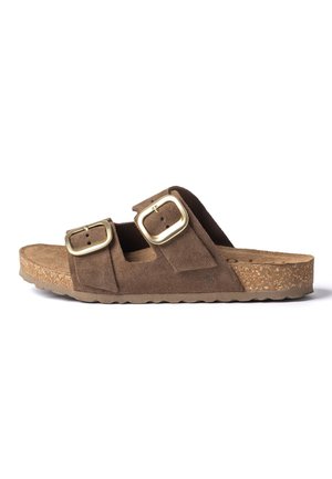 Bruine suède instapsandaal met twee verstelbare goudkleurige gespen en een kurken loopzool, zijaanzicht tegen een witte achtergrond.