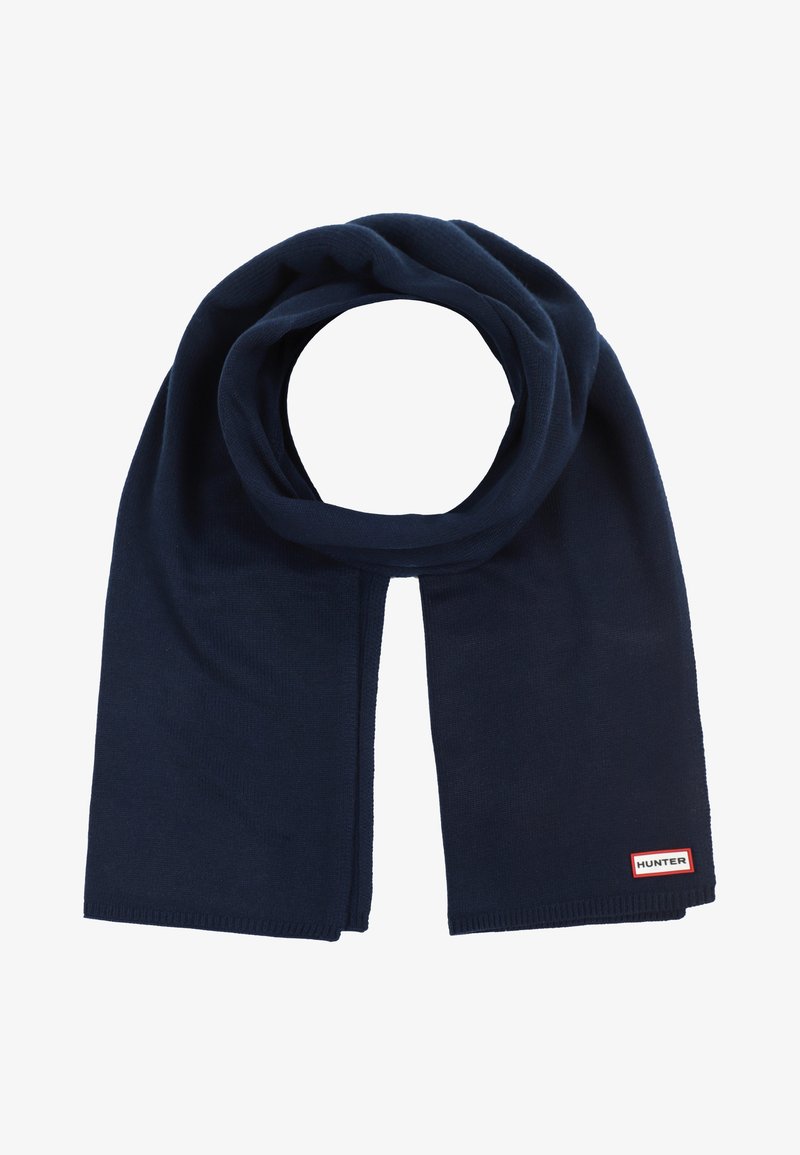 Écharpe en tricot bleu marine foncé pliée en boucle avec une petite étiquette rectangulaire rouge et blanche "HUNTER" à une extrémité.