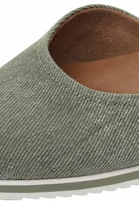 Grüne Leinenschlupfschuhe mit einer glatten Textur, runder Form und einer hellen, beige Innensohle. Verfügt über eine weiße Gummisohle und dezente Nähte.