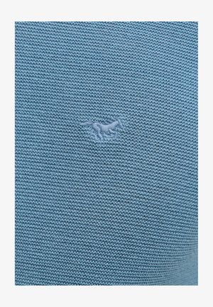 Világoskék kötött pulóver, textúrált mintázattal és egy kis hímzett lólogóval a közepén.