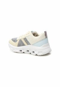 Zapatilla ligera con parte superior de punto en crema y gris con detalles de malla, puntera redondeada y suela blanca acolchada con cortes.