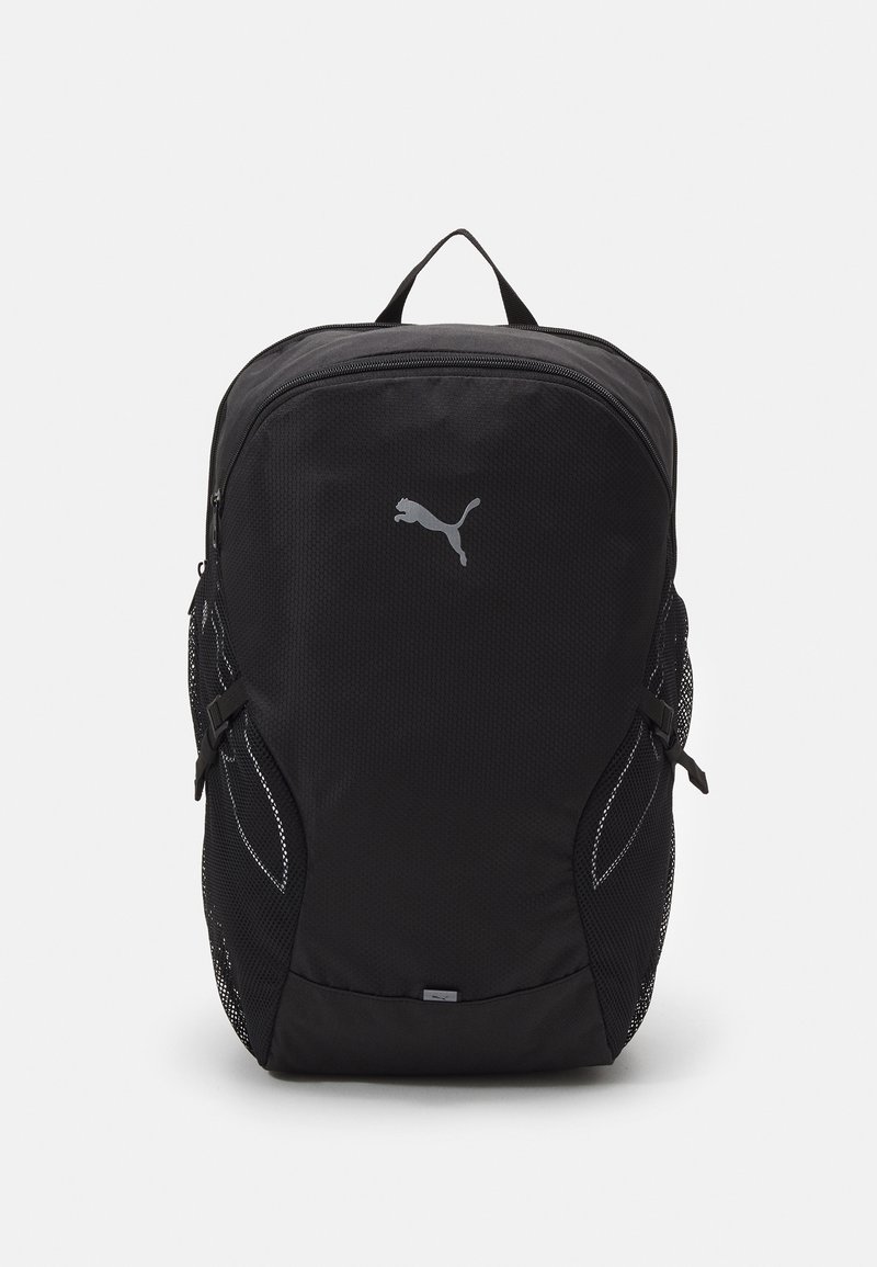 Sac à dos noir Puma avec poche zippée à l'avant, poches latérales en mesh, poignée supérieure et logo Puma réfléchissant sur le panneau avant.