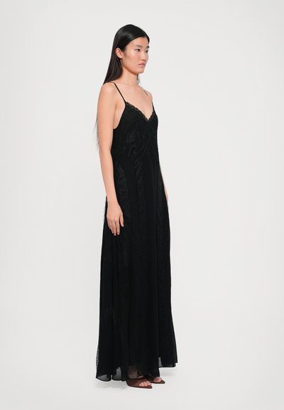 Must mustriga mustri kleit õhukeste rihmadega, millel on kitsas bodice ja voogav seelik. Küljel olevad tekstureeritud pitsaktsendid lisavad detaili.