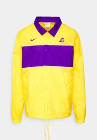 Cazadora amarilla y morada de Nike de los Los Angeles Lakers con botones a presión, puños elásticos y cordones ajustables en el dobladillo.