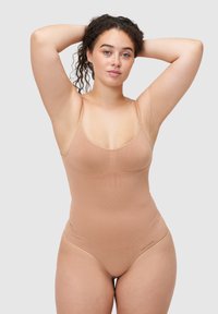 Naakte shapewear body met dunne verstelbare bandjes, een gladde textuur en naaddetails. Minimale branding op een onopvallende plek.