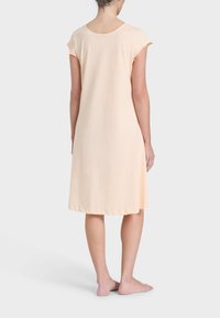 Camicetta da notte a maniche corte, lunghezza al ginocchio, in morbido tessuto pesco. Scollo tondo semplice con una vestibilità rilassata e senza hardware o motivi visibili.