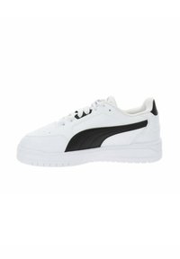 White sneaker featuring a black side swoosh, round toe, lace-up closure, and textured rubber sole with deep tread patterns.