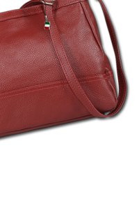 Rote Lederhandtasche mit strukturierter Oberfläche, ausgestattet mit einem langen Trageriemen und dezenten Akzentnähten. Enthält einen dekorativen Reißverschluss-Zipper.
