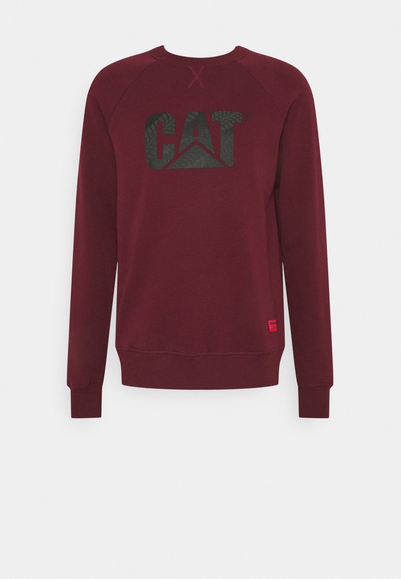 Sweat-shirt bordeaux à manches longues col rond avec logo noir "CAT" sur la poitrine et un petit patch rectangulaire rouge près de l'ourlet inférieur.