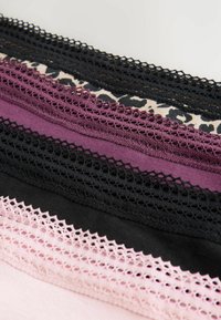 Spetsdetaljer i flera färger: svart, lila, rosa och ett leopardmönster. Har intrikata, öppenstickade mönster längs kanterna.