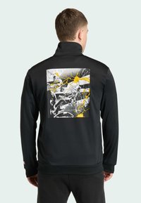 Czarna sportowa kurtka z graficznym nadrukiem na plecach w żółto-czarnych elementach. Wysoki kołnierz i ściągacze przy mankietach.