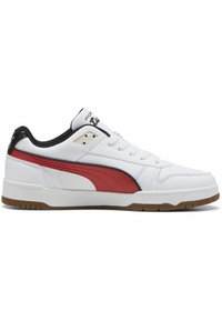 Bijela sneakersica s crvenom PUMA prugom, crnim akcentima i gumiranim potplatom. Glatka kožna gornja strana s okruglim vrhom i vezanjem.