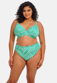 Groene bikini set met een chevronpatroon, gestructureerde cups en een hooggevoerde onderkant. Het materiaal lijkt glad met contrasterende accenten.