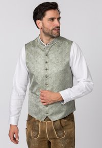 Hellgrüner, gemusterter Weste mit hohem Kragen, verziert mit dekorativen Knöpfen und einer Tasche, getragen über einem weißen Langarmhemd.