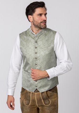 Light green patterned vest with a high collar, featuring decorative buttons and a pocket, worn over a white long-sleeve shirt.