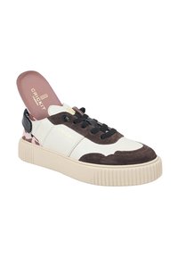 Sneaker bianco e marrone con materiali in suede e pelle, dotato di una suola beige testurizzata, lacci neri e un'accenno a motivo rosa sul tallone.