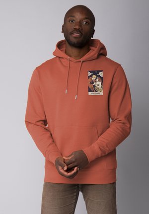 Terracotta hoodie met een voorzak, een trekkoord in de capuchon en een geprinte grafiek met twee figuren onder wolken. Zachte, gestructureerde stof.