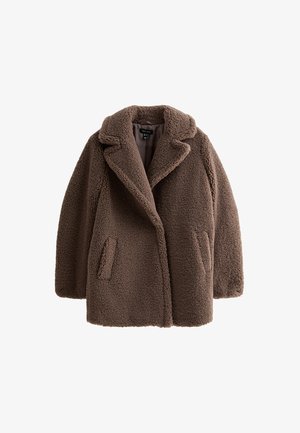 Cognackleurige teddyjas met een gestructureerde buitenkant, brede revers en zijzakken. Oversized pasvorm en eenvoudig ontwerp, dat het zachte, pluizige materiaal benadrukt.