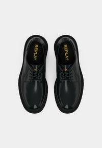 Sorte lædersko med en blank finish, snørebåndsdesign, rund tå og kontrastfarvet sort gummisål. Guld "REPLAY" logo på indersålerne.