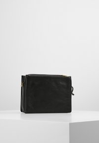 Czarna skórzana torba o teksturowanej powierzchni, prostokątnym kształcie, zamykana na zamek błyskawiczny, z dodatkami w złotym kolorze. Kompaktowy design odpowiedni na najpotrzebniejsze rzeczy.