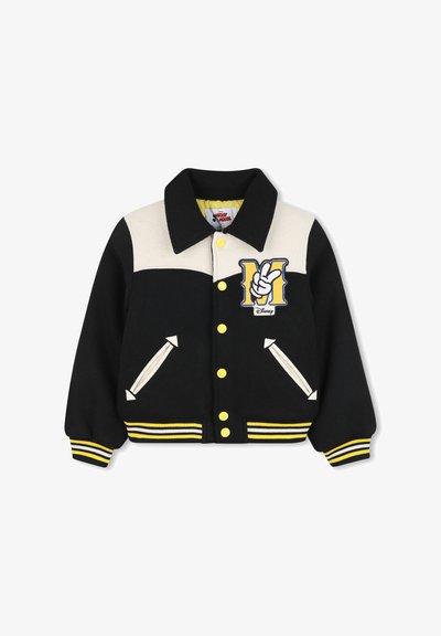 Giacca in stile varsity nera e crema con bottoni gialli, polsini a righe e un logo 'M' con un design di segno di pace sul petto.