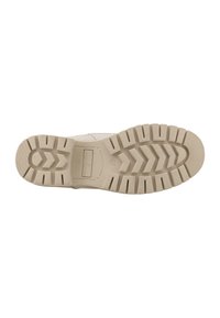 Podeszwa buta wykonana z teksturowanego, beżowego materiału gumowego. Posiada wzór bieżnika w zygzak oraz wypukły detal z logo. Opaque design.