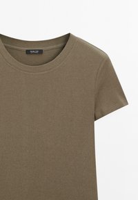 T-shirt di cotone verde oliva con maniche corte, scollo tondo e una texture liscia. Presenta un piccolo etichetta del marchio all'interno del colletto.