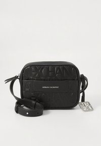 Black textured leather crossbody bag featuring embossed logo patterns, a front pocket, and an adjustable strap with a metal tag accent.