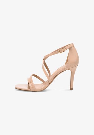 Sandalia de tacón alto de charol color nude, con finas tiras cruzadas y cierre de hebilla en el tobillo.