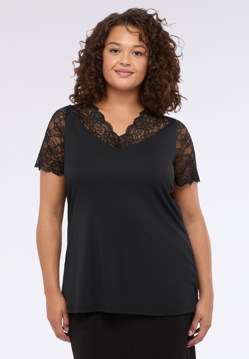 Top nero con maniche corte in pizzo e scollo a V. Tessuto morbido con vestibilità comoda, dotato di bordi in pizzo scallop sulle maniche e sullo scollo.