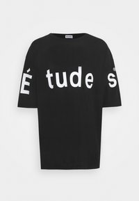 Musta, lyhythihainen puuvillainen t-paita. Edessä isot valkoiset kirjaimet, joissa lukee "É tude s", ja hihassa brändilogot.