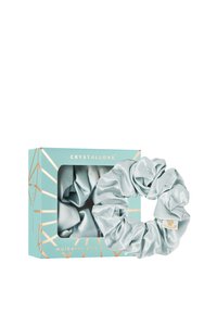 Moerbeizijden scrunchies in een zachte lichtblauwe kleur, gepresenteerd in een geometrisch patroon in een teal doos met gouden accenten.