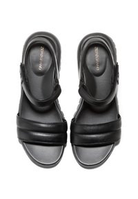Černé kožené sandály s širokými popruhy a hladkým povrchem. Polstrovaná stélka a nastavitelné zadní řemínky pro bezpečné nošení.