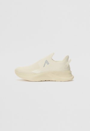 Lyse beige slip-on sneakers med struktureret strikoverdel, gummisål og minimal branding på siden. Har et slankt, strømlinet design.