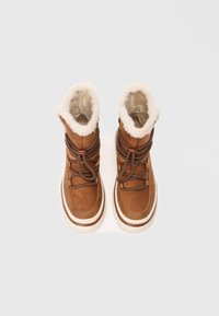 Bottines en daim marron avec doublure en fausse fourrure blanche, lacets marron et semelle en caoutchouc blanche épaisse. Conçues pour la chaleur et le confort.