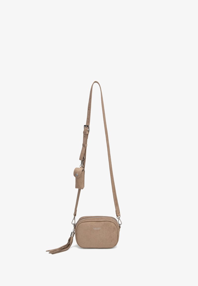 Sac bandoulière en daim beige avec sangle réglable, petite pochette attachée, fermeture éclair et pompon décoratif sur fond blanc.
