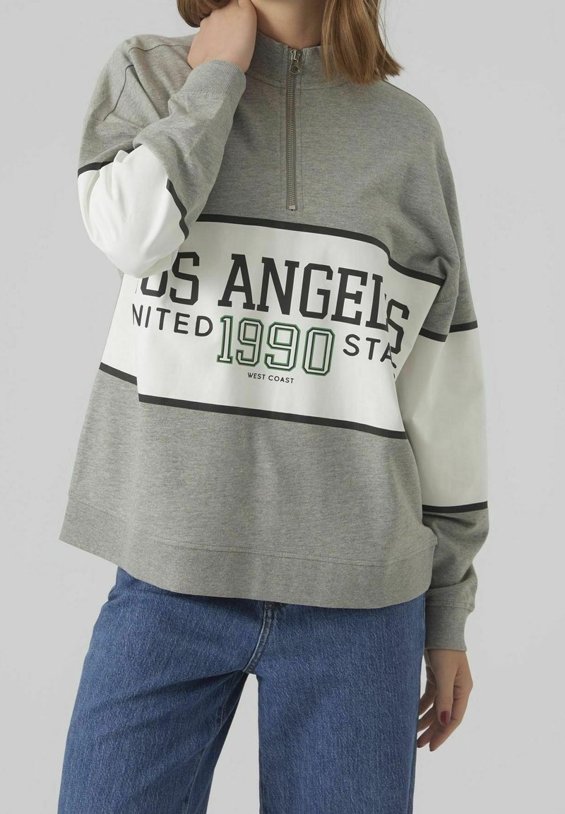 Grijze sweatshirts met rits en witte mouwen, met een grote zwarte en groene grafiek "LOS ANGELES 1990" en horizontale strepen.