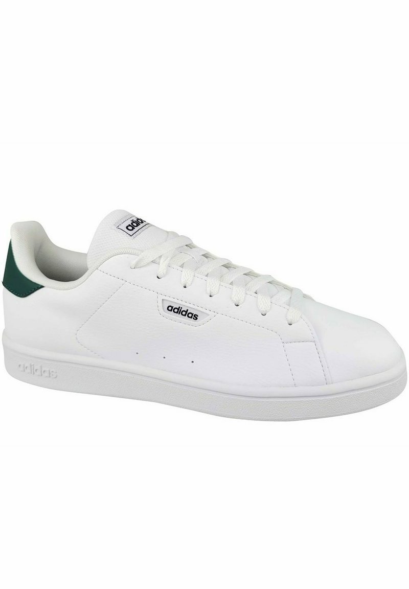 Sneaker in pelle bianca con accenti verdi sul tallone, punta arrotondata e suola piatta. Presenta un sistema di allacciatura e il logo Adidas.