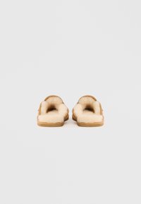 Svetlo rjav suknjič z mehkim, kremastim krznom. Okrogla oblika brez zadnjega dela, z narebrasto podplatom za boljši oprijem.