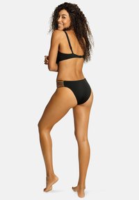 Czarny zestaw bikini o minimalistycznym designie, z regulowanymi ramiączkami i wycięciami w wysokich majtkach. Gładka tekstura.