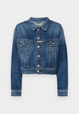 Atskirta džinsinė striukė vidutinio mėlynumo su sidabriniais metaliniais mygtukais, dviem priekinėmis kišenėmis ir klasikinio tipo apykakle. Susidėvėjusi tekstūra išilgai siūlių.