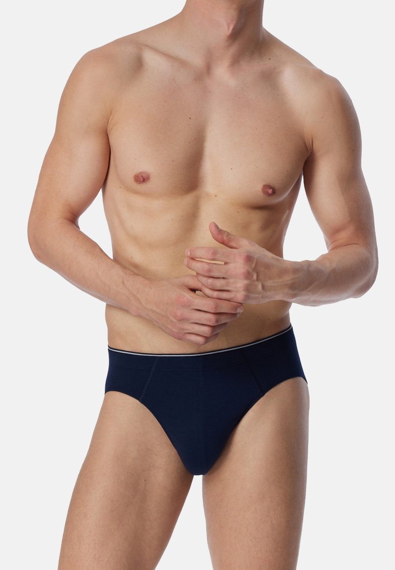 Culottes bleu marine en tissu doux, offrant une coupe ajustée et une taille élastique contrastante avec une bande blanche.