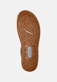 Suela de zapato de goma negra con patrón de textura, presentando una suela marrón y marcas de la marca visibles para mayor tracción y durabilidad.