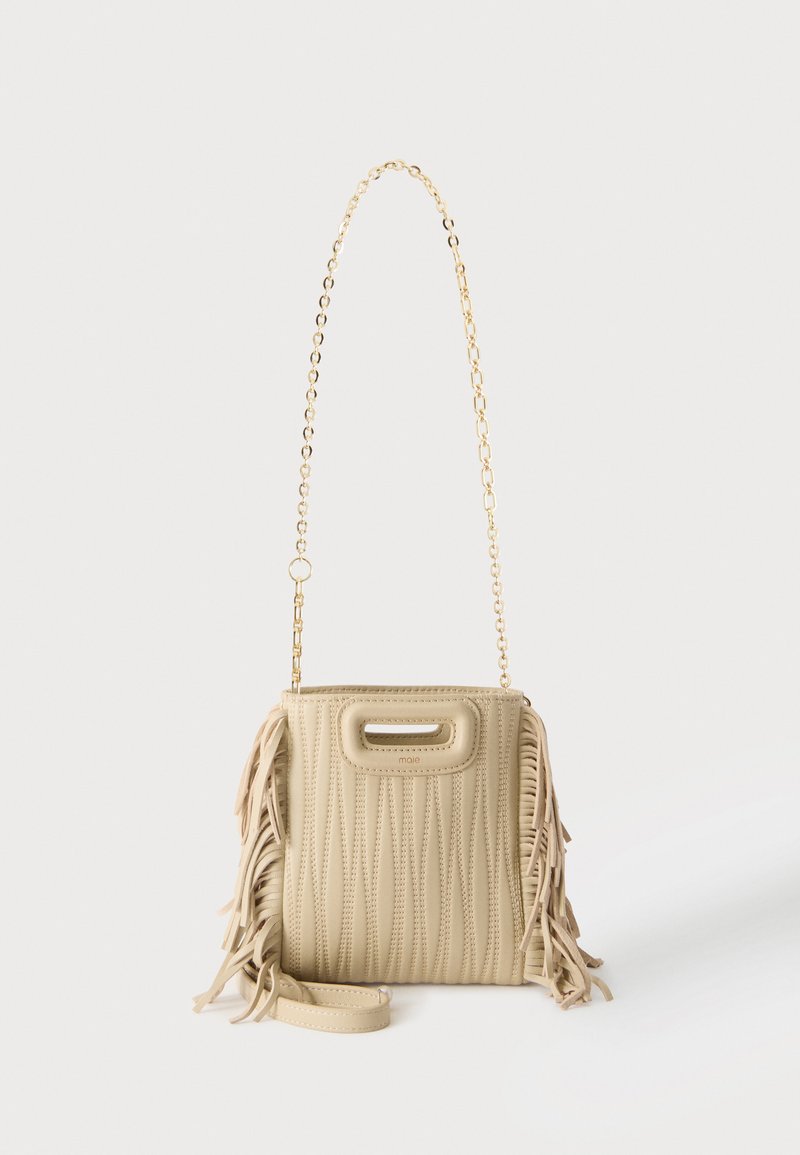 Sac à main matelassé beige avec des détails à franges sur les côtés, une bandoulière chaîne dorée et une petite ouverture sur la poignée supérieure.
