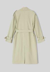 Trench-coat vert clair en tissu lisse, avec une taille ceinturée, des manches longues et des poignets retroussés. La vue de dos montre un design à coupe droite.